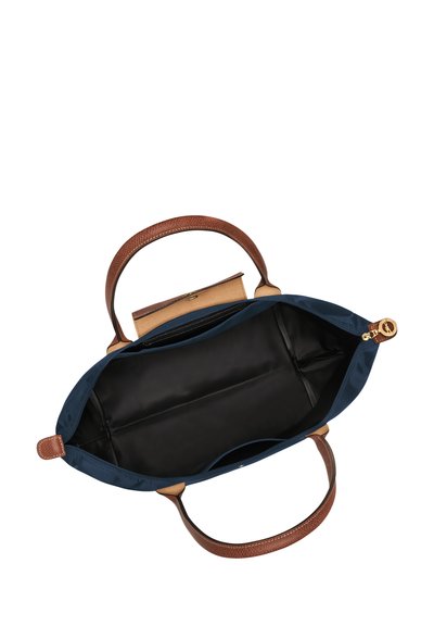 Navy blue tote bag with brown textured leather handles, black interior lining, and a zippered closure. Spacious, with a structured design.