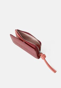 Portafoglio rosso in pelle con superficie testurizzata, chiusura con zip e una tracolla rosa. L'interno è foderato con un materiale leggero. Forma compatta e rettangolare.