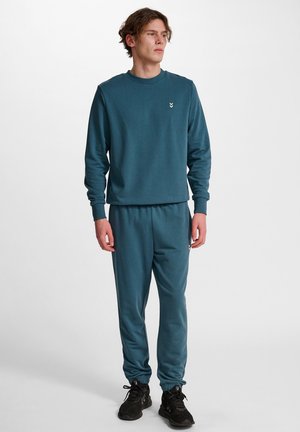Heren teal sweatshirt en joggers set in zachte stof, met ribbelmanchetten, elastische tailleband en een klein logo-accent op de borst.