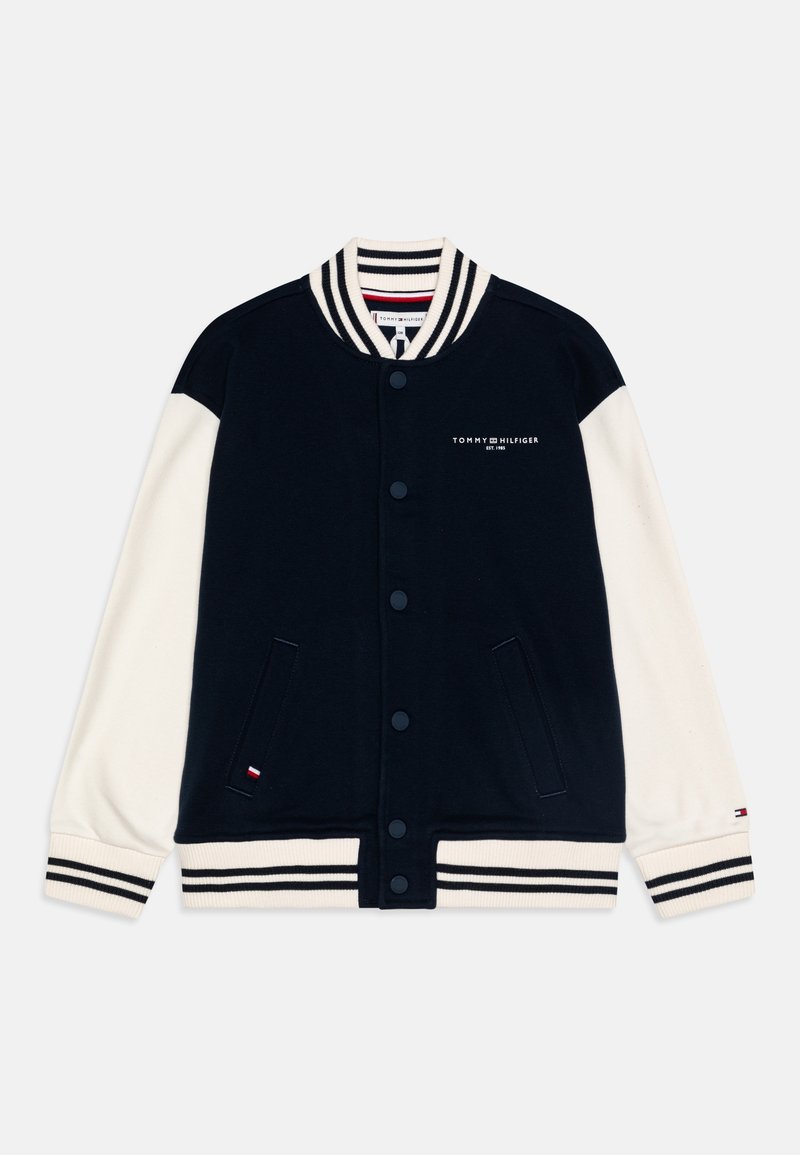 Veste varsity Tommy Hilfiger noire et blanche avec fermeture à boutons, col, poignets et bas rayés, et logo sur la poitrine et la manche.