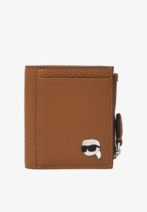 Portefeuille en cuir marron avec surface texturée, doté d'une fermeture éclair argentée et d'une icône de dessin animé portant des lunettes de soleil sur le devant.