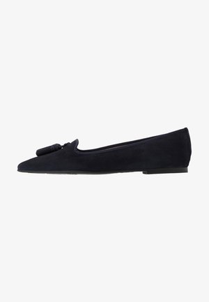 Navy suede ballet flats with a pointed toe, featuring a front tassel detail and a flat rubber sole. Smooth texture and minimalist design.
