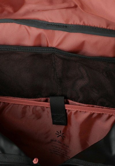 Interno di una borsa in tessuto rosso e nero, con una tasca in rete e una tracolla nera per la sicurezza dei compartimenti. Chiusura a cerniera visibile.