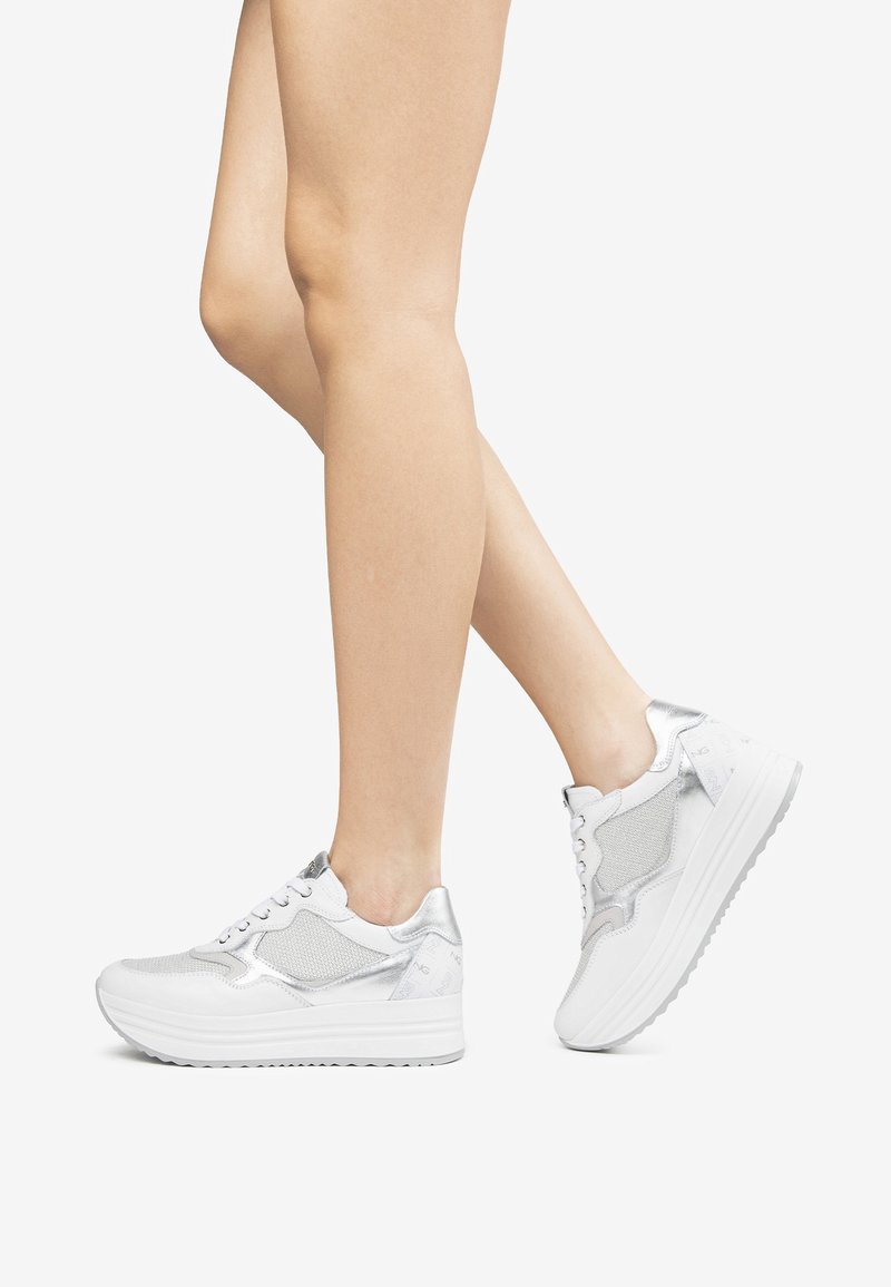 Sneaker platform bianche con accenti argentati, materiale in rete e design con lacci. Presentano una superficie testurizzata e suole lisce.