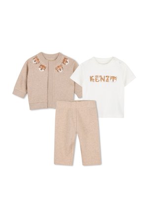 Pantaloni beige per neonato e cardigan con facce di tigre sul collo, abbinati a una camicia bianca a maniche corte con la scritta "KENZO" con lettere con stampa tigre.