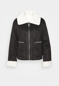 Svart mockajacka med vit pälskrage och manschetter, med framdragkedja och två sidofickor, framför en vit bakgrund.