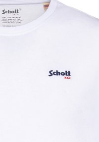 Witte katoenen t-shirt met een ronde hals. Voorzien van een geborduurd "Schott N.Y.C" logo in marineblauw en rood op de linkerborst. Soepele textuur.