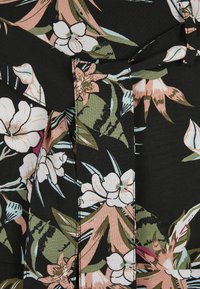Svart stoff med blomstermønster i hvite, rosa og grønne blomster. Detaljer inkluderer søm langs folder og en jevn tekstur.