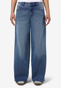 Ανοιχτό μπλε τ�ζιν παντελόνι με φαρδιά ποδιά και ξεθωριασμένο φινίρισμα, σχέδιο με πέντε τσέπες και φερμουάρ. Χαλαρή εφαρμογή με ίσια γραμμή από τη μέση έως το τελείωμα.