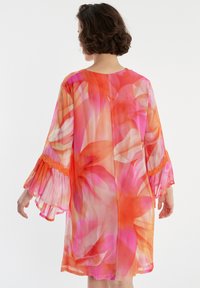 Luftiges, durchsichtiges Kleid in lebendigen Tönen von Pink und Orange mit ausgestellten Ärmeln und einem aufwendigen orangen Spitzenakzent an den Bündchen.