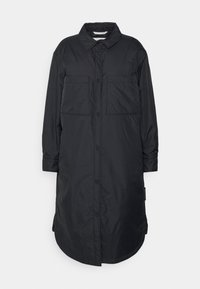 Long manteau noir matelassé à boutons avec col, manches longues, deux grandes poches poitrine et ourlet incurvé, présenté à plat sur un fond blanc.