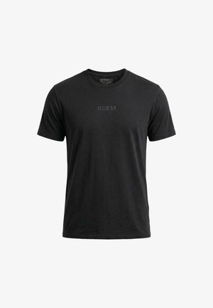 T-shirt noir à manches courtes avec col rond, imprimé "GUESS" en gris au centre de la poitrine.