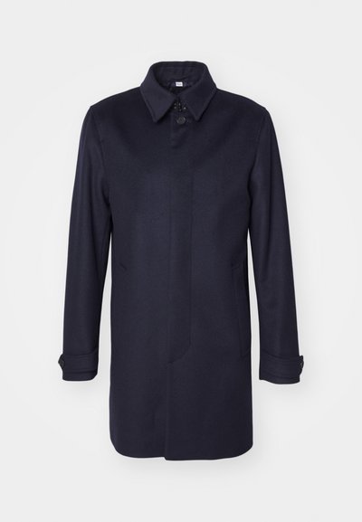 Navyblauer Wollmantel mit spitzem Kragen, einer Knopfschließe und zwei Fronttaschen. Er verfügt über lange Ärmel mit knöpfbaren Manschetten und eine gerade Silhouette.