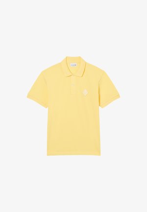 Żółta koszulka polo z fakturowanej tkaniny, z plisą na guziki, płaskim kołnierzykiem oraz haftowanym diamentowym logo na piersi.