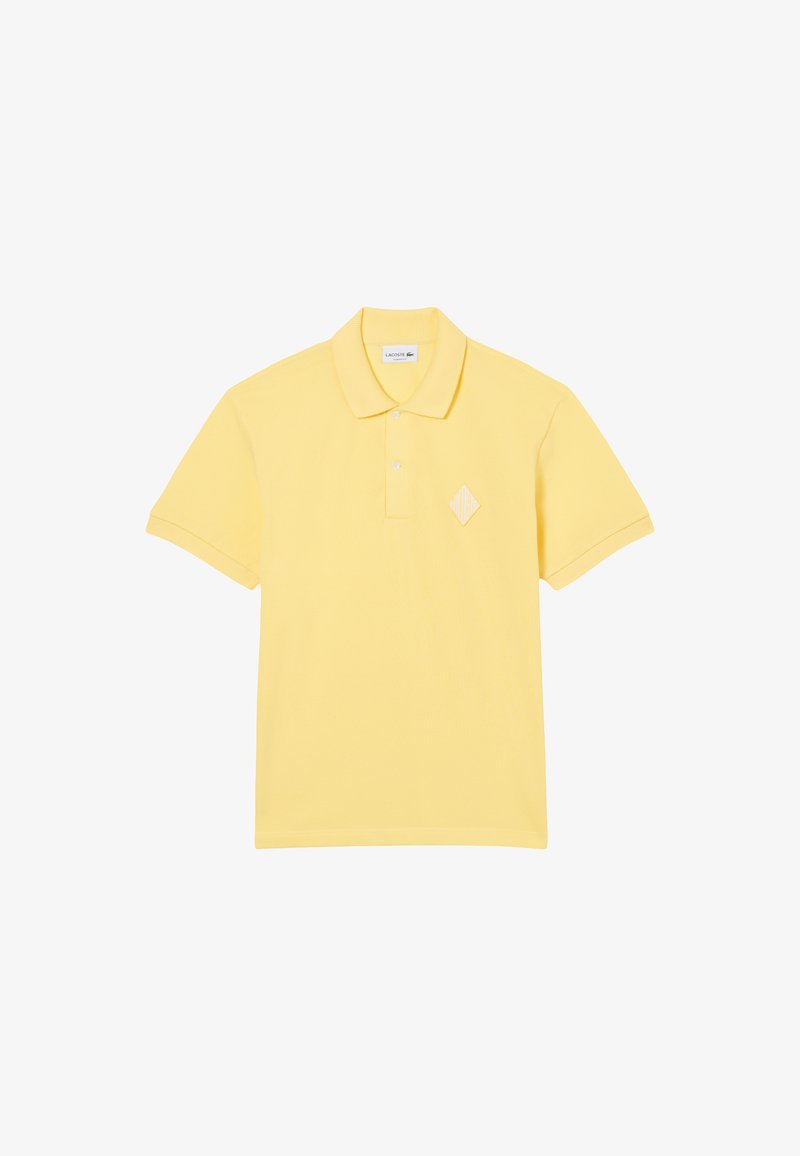 Polo gialla realizzata in tessuto strutturato, con patta con bottoni, colletto piatto e logo a diamante ricamato sul petto.