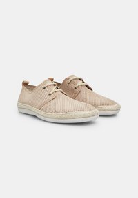 Beige perforated canvas shoes with a woven jute sole, featuring two laces and a tan leather accent at the heel.