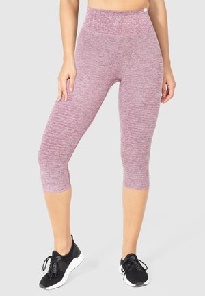 Leggings Capri in un tessuto borgogna testurizzato, con una vita alta. Abbinati a scarpe sportive nere.