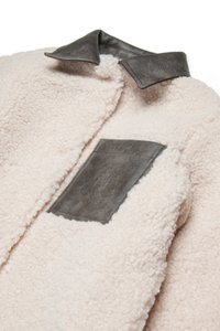 Fleecejakke i blødt lyserødt, med en grå læderlapel og en påsyet lomme med præget detaljering. Textureret og hyggeligt design.