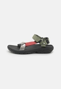 Black sandal with grey, red, and green straps. Features adjustable straps, textured sole, and a durable outsole for traction.