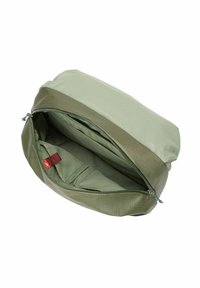 Bolsa de tela verde con una textura suave, cierre con cremallera y compartimentos internos. Presenta una pequeña etiqueta roja en su interior.