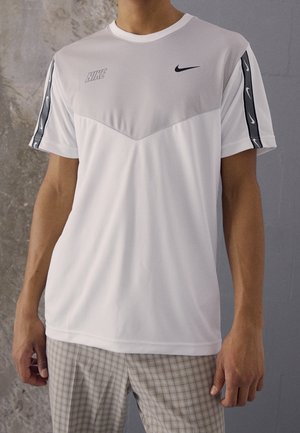 T-shirt de sport blanc avec un panneau gris, présentant des logos Nike et des accents noirs sur les manches. Confectionné en tissu lisse et léger.