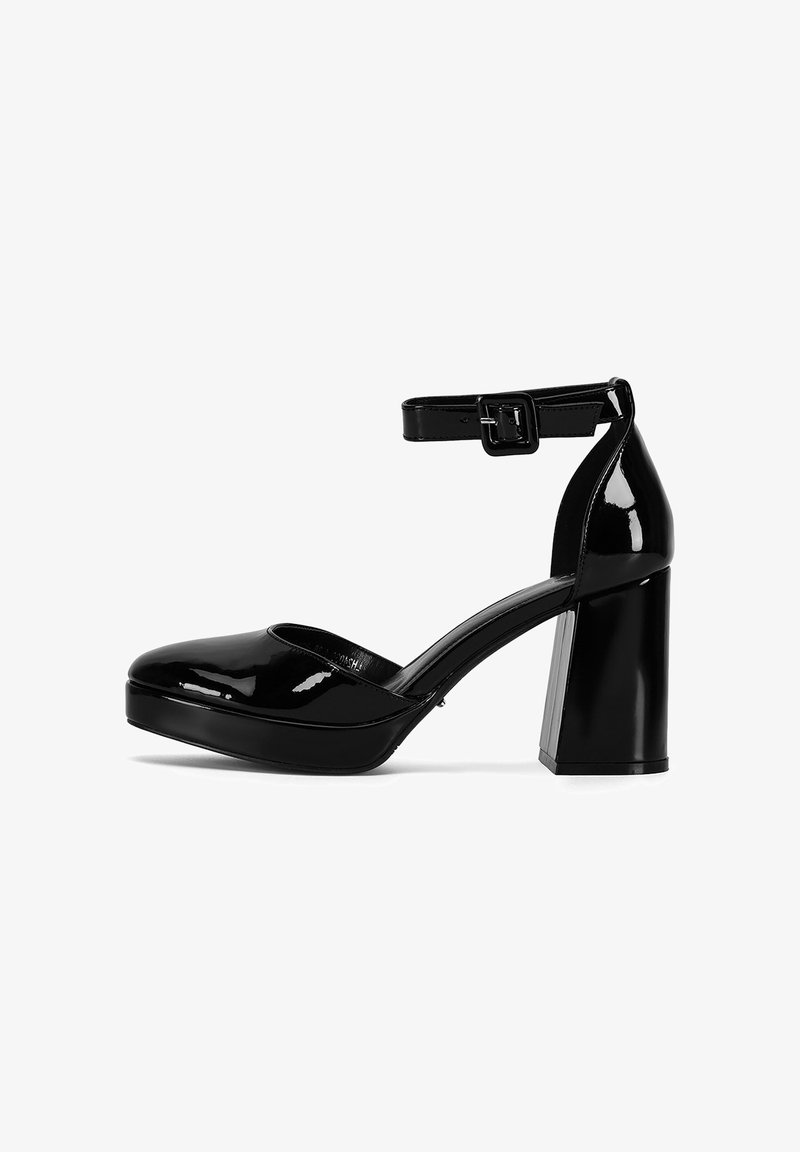 Zapatos de tacón alto de cuero charol negro con punta redonda, correa para el tobillo y tacón ancho. Acabado brillante y diseño de suela plataforma.