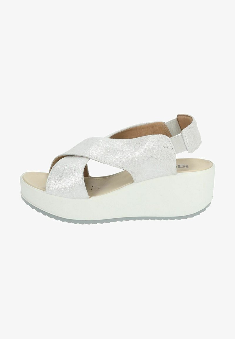 Sandali platform bianchi con un design incrociato lucido realizzati in materiale texturizzato. Presentano un sottopiede imbottito e una suola in gomma.