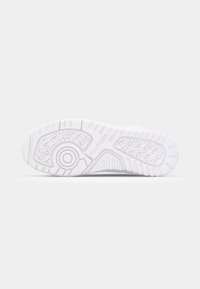 Semelle de chaussure blanche avec bande de roulement à motifs et le mot "HILFIGER" embossé près du centre sur un fond clair uni.