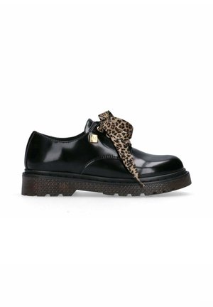 Scarpa in pelle verniciata nera con suola nera testurizzata, caratterizzata da un dettaglio a fiocco con stampa leopardata e un accento dorato di lato.