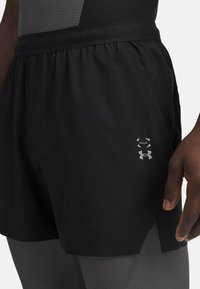 Mustad must athletic shorts elastseelikuga, küljetaskute, hõbedase logoga ja jagatud läänega, mis tagavad suurema liikumise vabastuse.