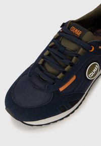 Marineblaue Sneakers aus strukturiertem Stoff mit Wildlederakzenten. Mit orangefarbenem Logo, verstärkten Ösen und einer gepolsterten Sohle.