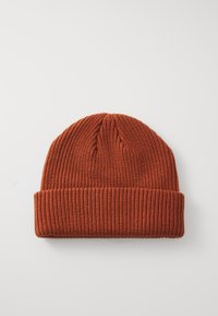 Gebreide beanie in diep oranje met een geribbelde textuur en opgerolde manchette. Ronde bovenkant en zachte stof, geschikt voor koud weer.