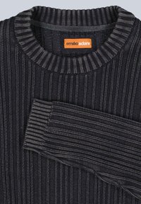 Dunkler Rippstrickpullover mit Rundhalsausschnitt, hellgrauen horizontalen Streifen und einem orangefarbenen Markenlabel am inneren Nacken.