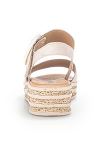 Sandales rembourrées beige clair avec une sangle arrière, semelle plate-forme dotée d'accents en jute texturé, et un grand motif floral décoratif.