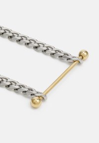 Silver chain link necklace featuring a gold-tone bar and round ends, emphasizing a contrasting metallic finish with smooth texture.