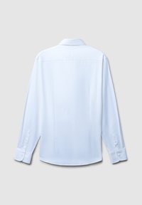 Vista posteriore di una semplice camicia bianca a maniche lunghe con polsini abbottonati su uno sfondo grigio chiaro.