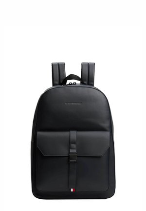 Zaino in pelle nera con spallacci imbottiti, tasca frontale a patta chiusa da una fascetta e piccolo logo tricolore come dettaglio nella parte inferiore.