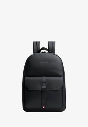 Zaino in pelle nera con spallacci imbottiti, tasca frontale a patta chiusa da una fascetta e piccolo logo tricolore come dettaglio nella parte inferiore.