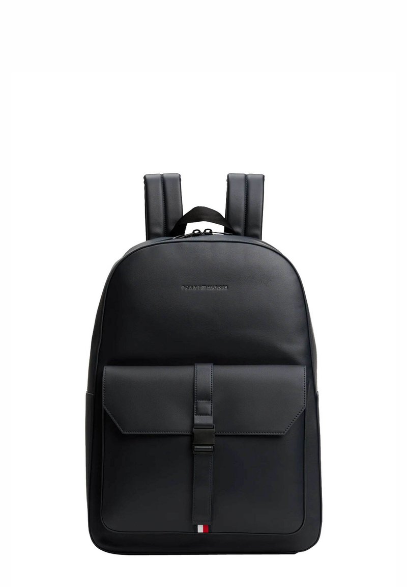 Zaino in pelle nera con spallacci imbottiti, tasca frontale a patta chiusa da una fascetta e piccolo logo tricolore come dettaglio nella parte inferiore.