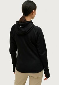 Felpa nera con cappuccio dal tessuto morbido, caratterizzata da un logo sul retro e fori per i pollici nei polsini per un comfort aggiuntivo.