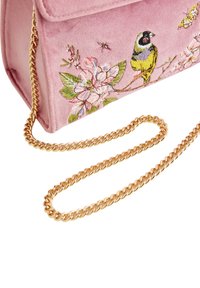 Bolso de terciopelo rosa con flores bordadas y un diseño de pájaro, que cuenta con una correa de cadena dorada y un cierre de solapa.