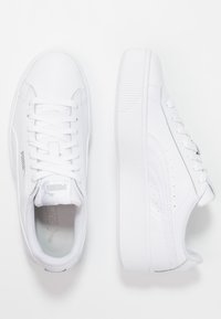 Zapatillas blancas con un upper sintético suave, punta redonda, cierre de cordones y suela de goma texturizada. Presenta una marca sutil y acentos perforados.