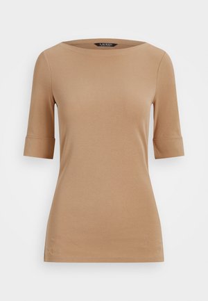 Beżowa dopasowana damska bluzka z rękawami do łokcia, dekoltem typu łódka i podwiniętymi mankietami, prezentowana na białym tle.