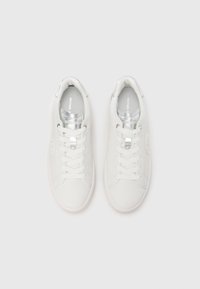 Valged tossud, millel on sile nahast pealmine osa, ümar varbakate, keelega ja kraega hõbedased detailid ning tekstuuriga kummist tallad.