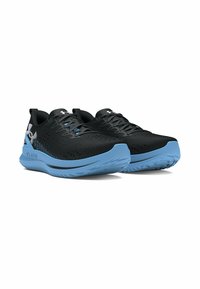 Baskets de sport noires avec une tige perforée, dotées d'une semelle intermédiaire bleue, d'une semelle extérieure texturée et d'un design minimaliste. Accentuées par un logo argenté.