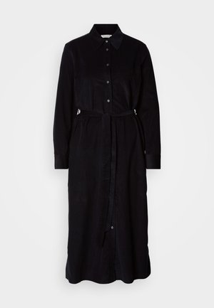 Črna srajčna obleka z ovratnikom, dolgimi rokavi, zapiranjem na gumbe in pasom za prilegajočo se zavezanost. Gladek tekstura tkanine.