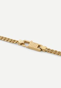 Goldfarbener Armband mit einem strukturierten Verschluss, der mit dem Markennamen graviert ist. Glatte, glänzende Oberfläche mit klassischem Kettendesign.