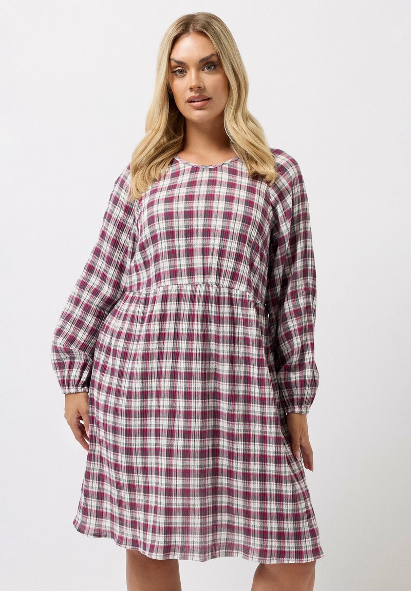 Ruudullinen mekko purppurassa, valkoisessa ja harmaassa, jossa on pitkät hihat, pyöreä kaula-aukko ja kerätty vyötärö rentoa istuvuutta varten.