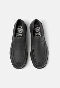 Chaussures noires à enfiler avec une finition en cuir lisse, une large bride sur le dessus et une semelle en caoutchouc texturée pour une meilleure adhérence.