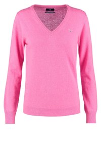 Pull en V rose en laine de mouton extra fine, avec des manches longues et des poignets et un ourlet côtelés. Détail du logo discret sur la poitrine.